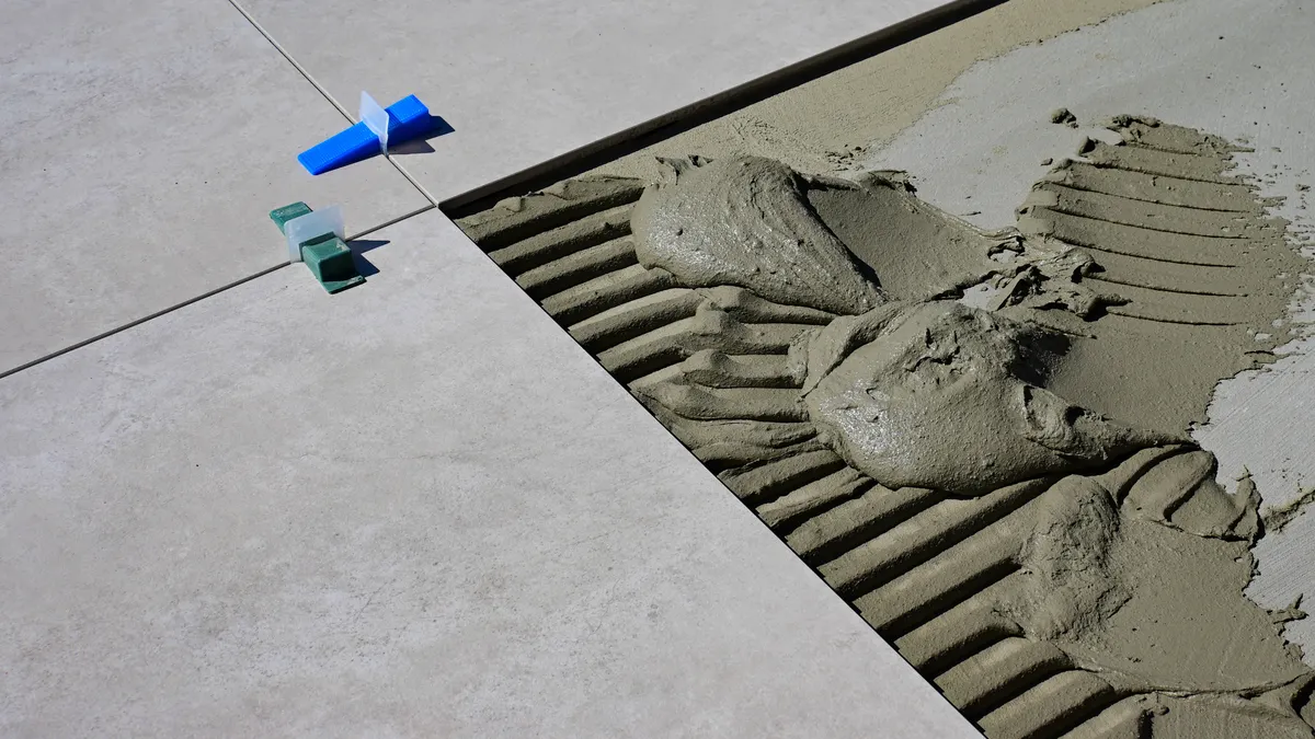 Fresh concrete being finished beside a control joint