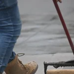 Person rolling sealant or coating onto pavement